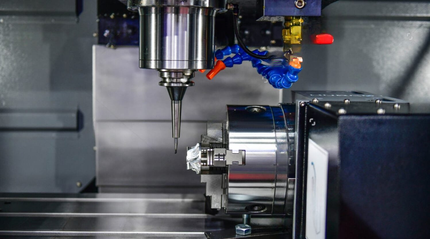 4-axis CNC mill spindle machining a metal impeller held in a rotary chuck